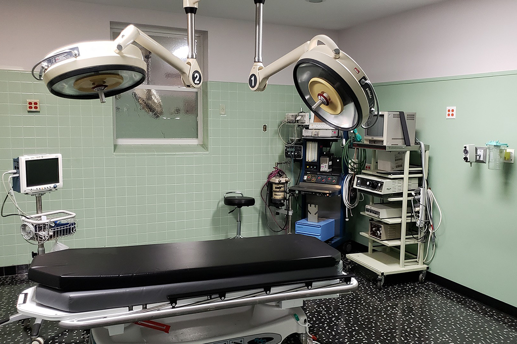 An operating room with a bed and Medical Electrical Equipment