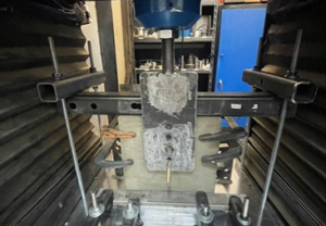 Concrete anchor specimen secured in test fixture for shear strength testing