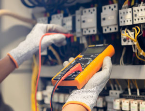 Electrician engineer uses a multimeter to test the electrical in