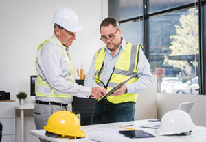 Construction Product Documentation Review Construction professionals reviewing technical documents for building product compliance
