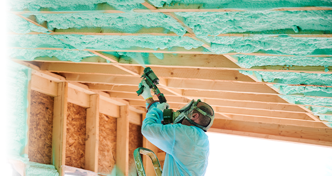 CAN/ULC-S705.1 Spray Foam Insulation Application Worker applying spray polyurethane foam insulation during residential construction